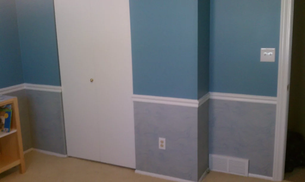 Blue paint on upper wall wallpaper on lower wall